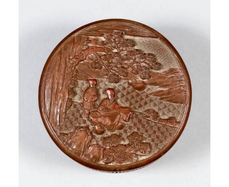 A Chinese red cinnabar lacquer circular box and cover, the cover carved in relief with a seated scholar playing a Qin, an att