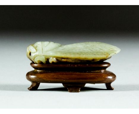 A Chinese white and brown jade carving of a cicada, naturalistically carved, 2.25ins (6cm) overall (late Ming Dynasty - 17th 