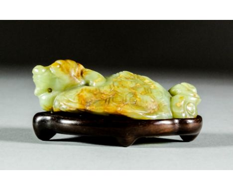 A Chinese celadon jade carving of a recumbent tortoise with brown inclusions, 3.5ins (9cm) overall (Qing Dynasty - possibly l
