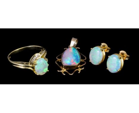 A modern 14ct gold mounted opal and diamond ring, the oval cut opal approximately 1ct bordered to either side by three small 