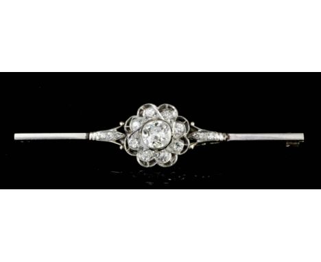 An Edwardian silvery coloured metal mounted all diamond set flowerhead pattern bar brooch, the central old cut stone approxim