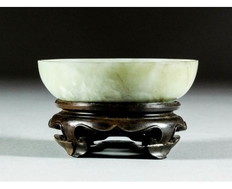 A Chinese celadon jade circular shallow dish with grey inclusions, the centre carved with a Chilong dragon with Lingzhi fungu