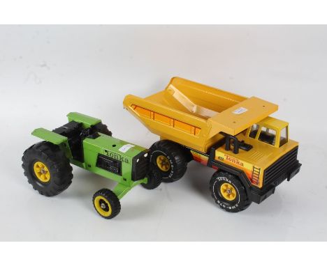 Two tin plate Tonka toys, the first in the form of a yellow tipper truck, 37cm long, the second in the form of a green tracto