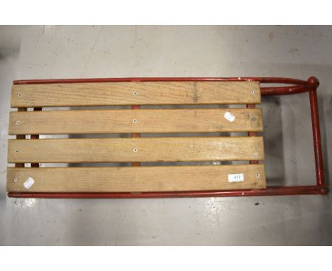 A vintage toboggan sledge having metal frame and wood seat