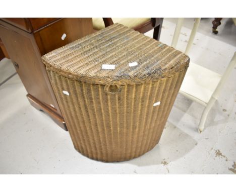 A vintage Lloyd Loom corner linen basket
