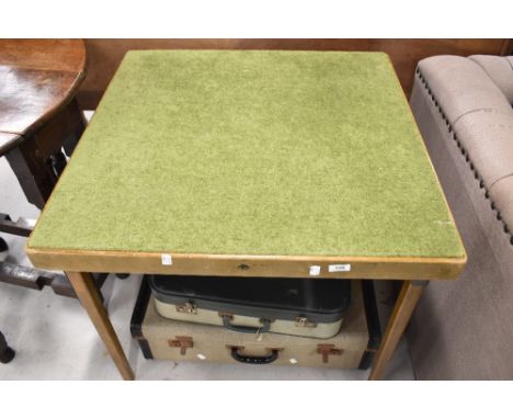 A vintage fold out card table and two vintage suitcases