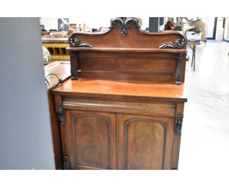 A Victorian mahogany chiffonier sideboard having shaped shelf ledge back , concealed drawer and double cupboard , width appro