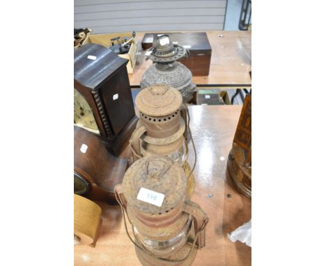 A Victorian pewter oil lamp base and two storm lanterns