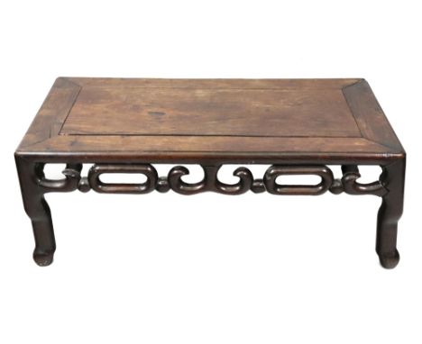 A Chinese rosewood low table, 19th century, the moulded rectangular top above pierced scroll friezes, on rounded splayed legs