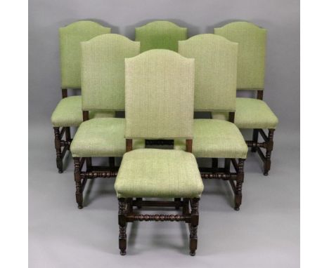 A set of six reproduction late 17th century style oak dining chairs, with high arched upholstered backs and stuff over seats,