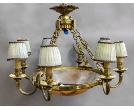 A French gilt metal eight light chandelier, early 20th century, with domed circular alabaster shade, within a ribbon tied ree