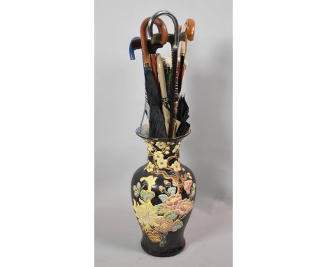 An Oriental Ceramic Six Stand Vase Decorated in Relief Together with a Collection of Various Modern Walking Sticks and Umbrel