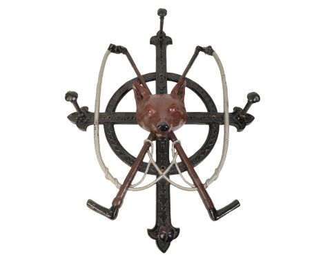 AN EDWARDIAN CAST IRON WHIP RACK with cast iron fox masks and hunting crops, 74cm x 56cm
