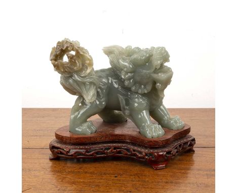 Carved jade model of a dog of foChinese, in the Ming style on a wood base, 16cm long x10.5cm highThis lot is from the estate 