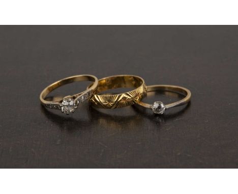 Three 18ct gold rings the first a band with textured and star cut decoration, size N, 3g approx overall, the second a diamond