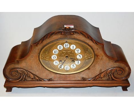 An early 20th century German walnut cased mantel clock having porcelain inset Arabic numerals, eight day movement striking on