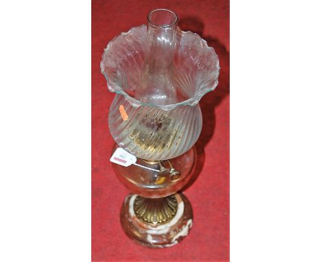 A Victorian oil lamp having swirled clear glass shade above a glass reservoir on brass pedestal and marble base