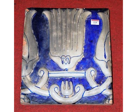 A large Persian pottery tile, on a blue ground with applied floral decoration, 38 x 31cm