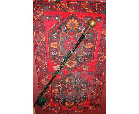 A brass capped and ebonised turned wood walking stick; together with a Persian prayer rug (2) 