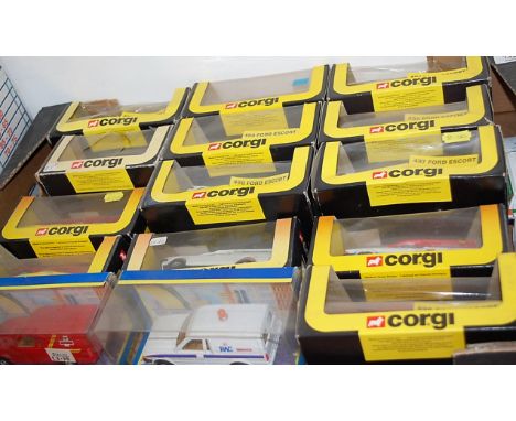 A box of model Corgi vehicles, mostly being delivery vans