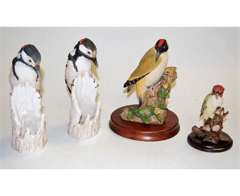 A Country Artist resin bird; together with a pair of W Goebel porcelain birds; and a Wild Track of Scotland resin bird on woo