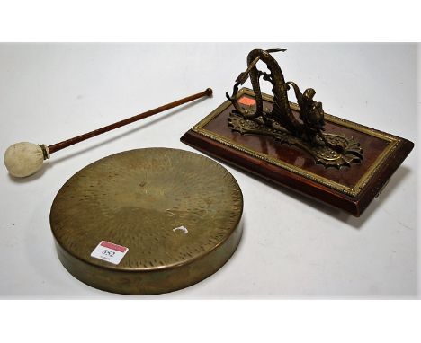 An early 20th century wall mounted dinner gong, the bracket in the form of a dragon, on mahogany and brass mounted backing, w