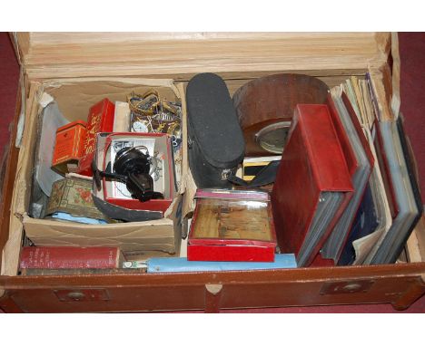 An early 20th century canvas, wooden and metal bound hinged travelling trunk, containing various mixed effects to include man