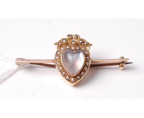 A moonstone and seed pearl bar brooch, the heart shaped moonstone in rubover mount, surrounded by seed pearls and surmounted 