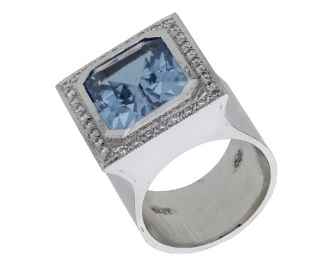 An aquamarine and diamond ring, the cut-cornered aquamarine in a rubover setting within a surround of brilliant-cut diamonds,