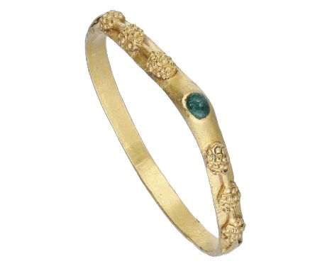 A Medieval gold emerald stirrup ring, early 14th century, the hoop of D-shaped cross-section, the yellow gold with raised tri