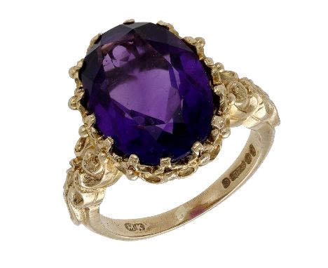 A 9ct gold and amethyst single stone ring, 1972, the oval-cut amethyst claw-set to a beaded mount and scrollwork shoulders, L