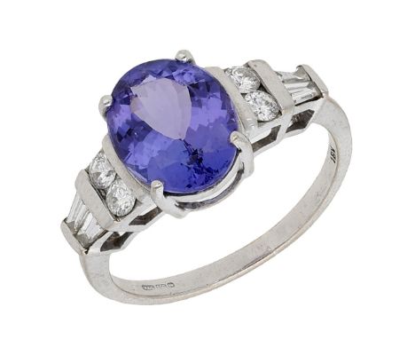 A tanzanite and diamond ring, the oval-cut tanzanite between tapered shoulders set with brilliant and baguette-cut diamonds, 