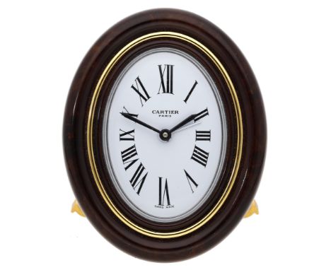 Cartier. A gilt metal oval desk timepiece with alarm, Baignoire, Ref. 7519, circa 1990. Movement: quartz. Dial: white, Roman 