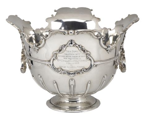 An Edward VII silver trophy bowl, the shaped rim cast with ‘S’ scrolls, the girdled body with hinged handles and a presentati