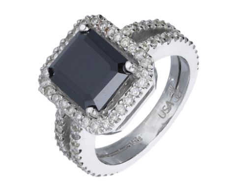 A black diamond and diamond cluster ring, the step-cut treated black diamond within a surround of brilliant-cut diamonds, bet