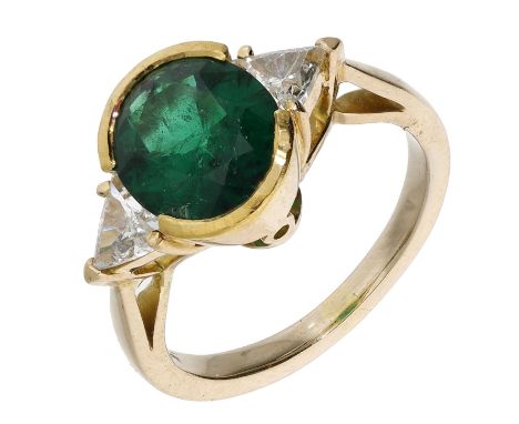 An emerald and diamond ring, the oval-cut emerald with a trilliant-cut diamond to either side, total diamond weight approxima