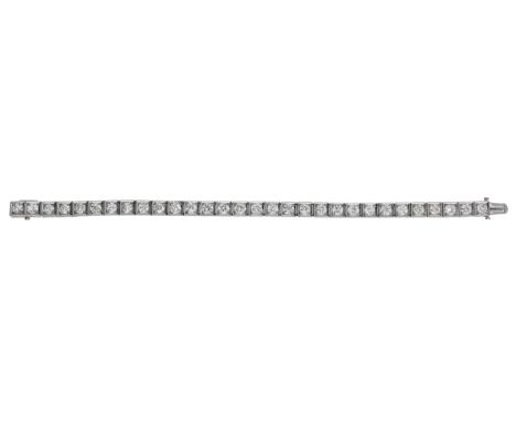 An Art Deco diamond line bracelet by Chaumet, circa 1925, set with a continuous row of old brilliant-cut diamonds, the settin