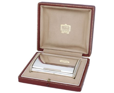 A silver cigarette case by Cartier London, 1948, the polished bicolour case of flattened cylindrical form, with hinged lid an