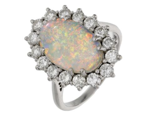 An opal and diamond cluster ring, set with an oval opal cabochon within a surround of brilliant-cut diamonds, mounted in 18ct