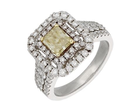 A diamond cluster ring, set with a cut-cornered radiant-cut diamond of yellow tint, weighing 1.01 carats, within a two-row su