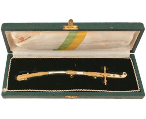 A BRAZILIAN MAMELUKE LETTER OPENER, 11.25cm curved blade etched with scrolling foliage and DUQUE DE CAXIAS, gilt hilt, contai