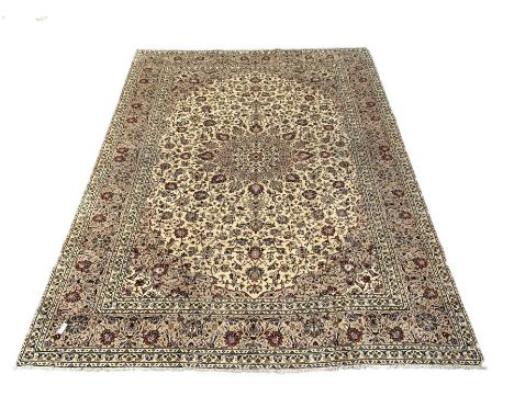 Persian fine Kashan ivory ground carpet centred by a floral medallion 292cm x 390cm