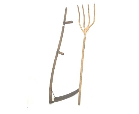 Late 19th/ Early 20th century four pronged elm hay fork, (H144cm) and a two handled scythe 