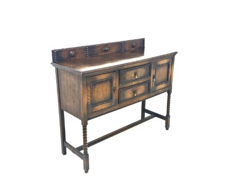 Early 20th century oak dresser, the raised back with applied carved decoration over two drawers and two cupboards, raised on 