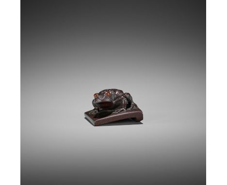 RYUKEI: A FINE DARK WOOD NETSUKE OF A TOAD ON ROOF TILE By Ryukei II, signed Ryukei 龍珪Japan, Edo (Tokyo), mid-19th century, E