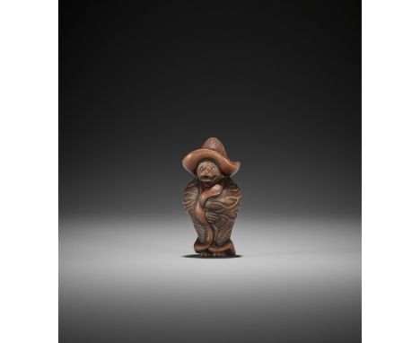 MASAKATSU: A WOOD NETSUKE OF A TANUKI WRAPPED IN LOTUS LEAVES Signed Masakatsu 正勝Japan, 20th centuryThe mythical shape-shifti