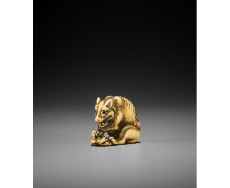 TOMOTADA: A FINE IVORY NETSUKE OF A WOLF WITH HAUNCH OF VENISON By Tomotada, signed Tomotada 友忠Japan, Kyoto, late 18th centur