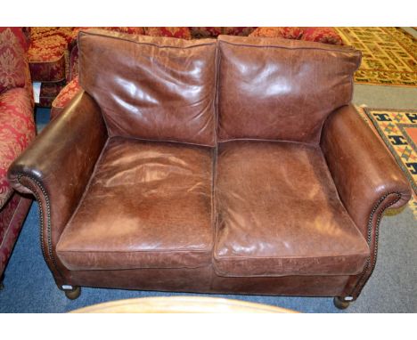 A studded brown leather two seater sofa