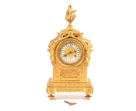 French gilt cased mantel clock, flame finial, satyr mask to the shoulders, gilt dial with enamel numeral plaques, cylinder mo