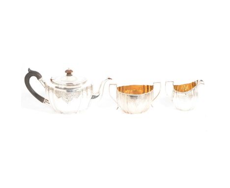 Edwardian silver and silver-gilt three piece teaset, London 1908/1910, teapot with ebonised handle and finial, makers marks r